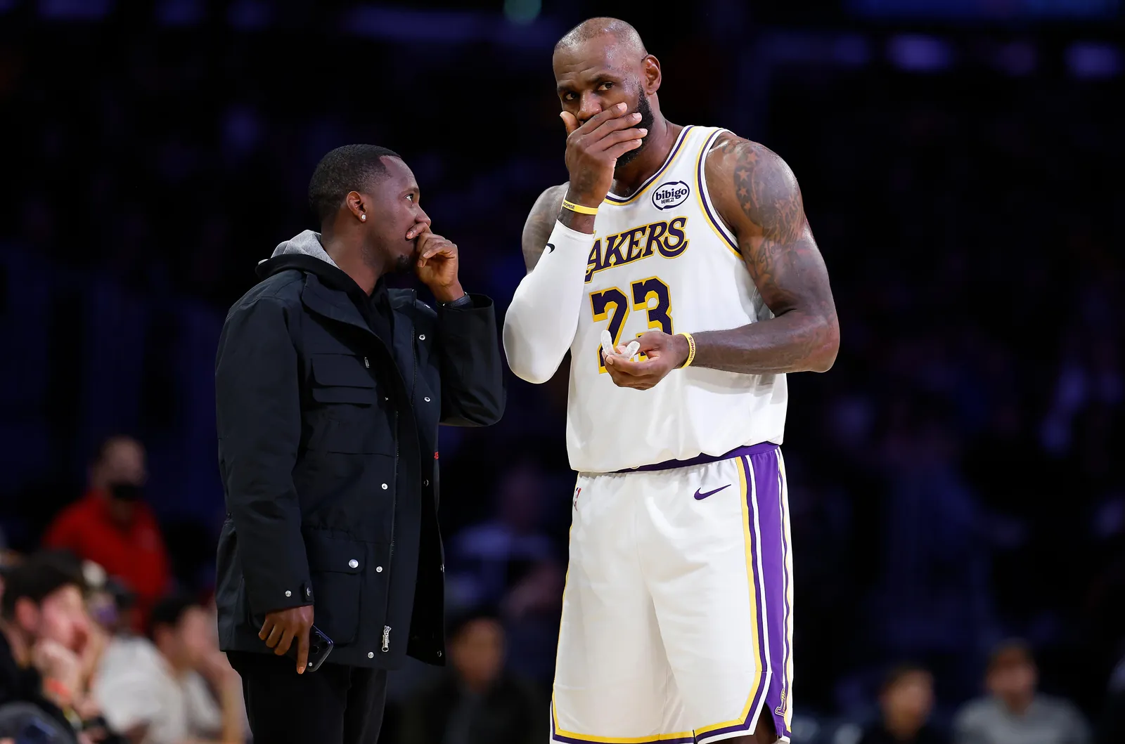 LeBron James talking to Rich Paul on the basketball court.